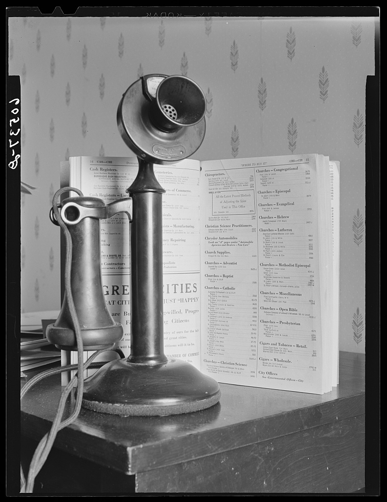 A telephone and a telephone directory on a table in Dubuque, Iowa, in April 1940, photographed by John Vachon for the Farm Security Administration.
