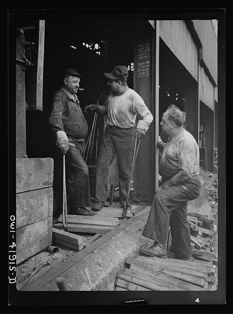 Factory workers in Southington, Connecticut, talking with their foreman, May 1942, photographed for the Office of War Information.