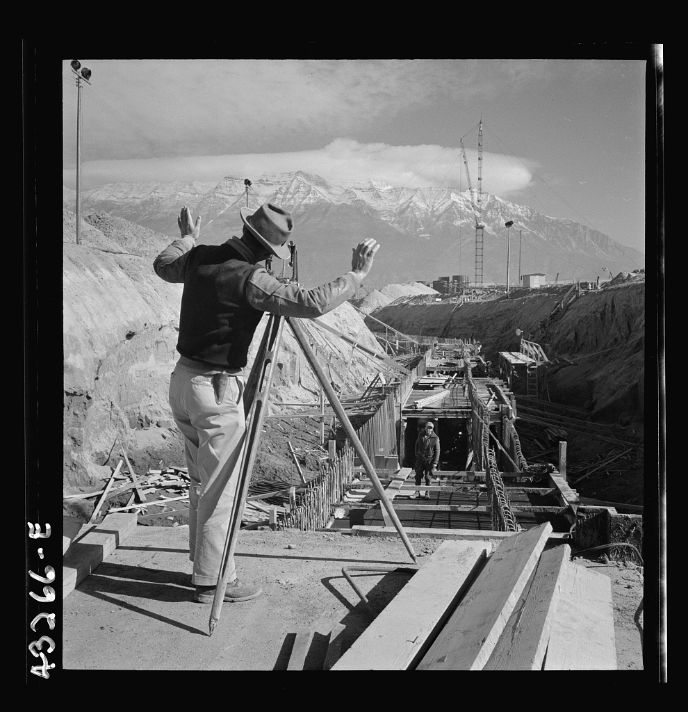 A surveyor at his instrument running lines for a water intake tunnel at the Columbia Steel Company site in Geneva, Utah, November 1942, before the mill was built.
