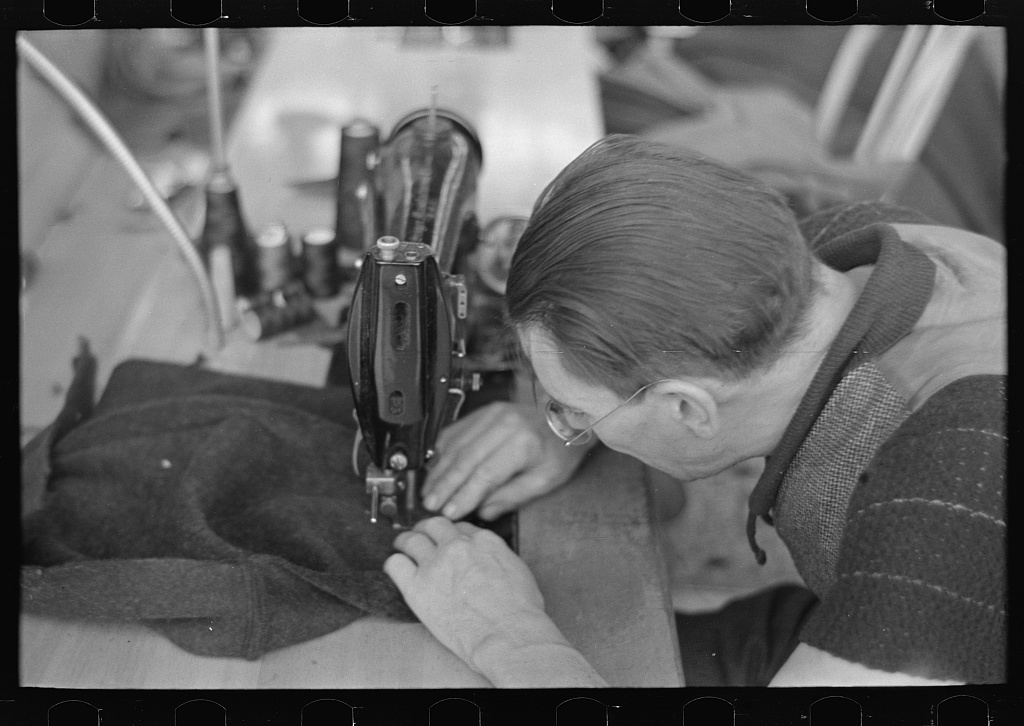 Close-up of a man working at a sewing machine in a garment factory at Jersey Homesteads, Hightstown, New Jersey, November 1936, photographed by Russell Lee